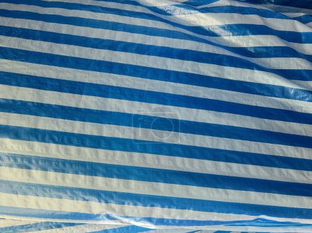 eine Fotografie eines blau-weiß gestreiften Leintuchs mit weißem Streifen.