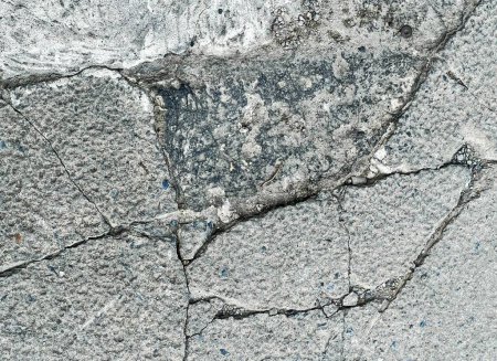 una fotografía de un primer plano de una grieta en una pared de hormigón.