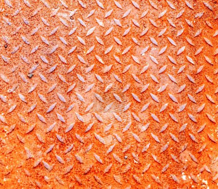 a photography of a metal surface with a diamond pattern.