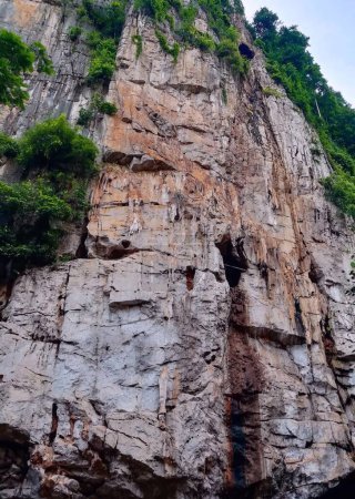 a photography of a man climbing up a rock face.