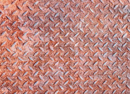 eine Fotografie einer Metalloberfläche mit einem Muster diamantförmiger Linien.