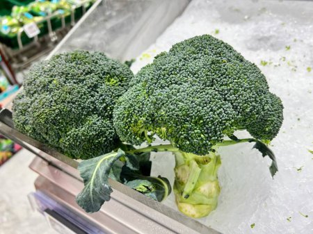 eine Fotografie eines Bündels Brokkoli, der auf einer Theke sitzt.