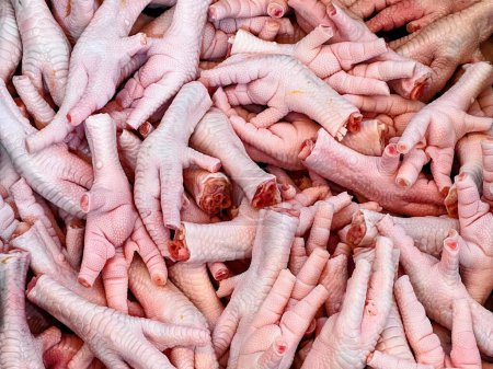 una fotografía de una pila de patas de pollo con mucha sangre en ellas.