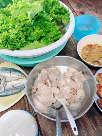 a photography of a table with a bowl of fish, a bowl of salad, and a bowl.