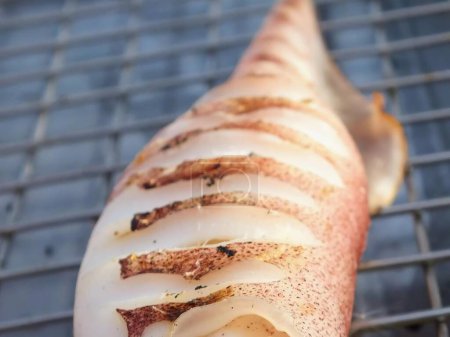 a photography of a fish is being cooked on a grill.