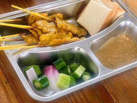a photography of a metal tray with a variety of food in it.