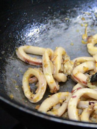una fotografía de una sartén con calamares y otros alimentos cocinados en ella.