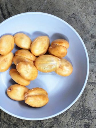 a photography of a bowl of peeled potatoes on a table.