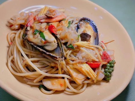 a photography of a plate of pasta with seafood and vegetables.