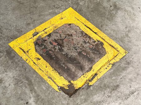 Téléchargez les photos : Une photographie d'un panneau carré jaune sur un sol en béton. - en image libre de droit