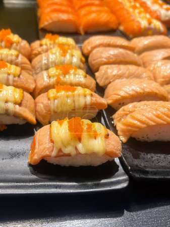 una fotografía de una bandeja de sushi con una variedad de ingredientes.