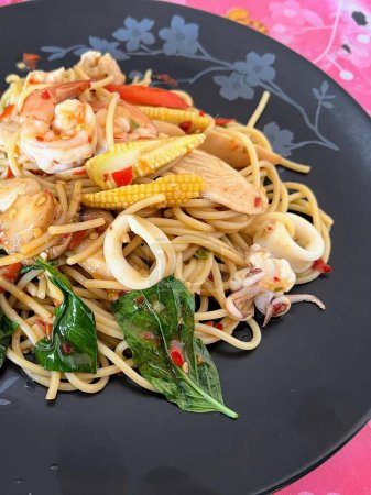 a photography of a plate of noodles with shrimp and vegetables.