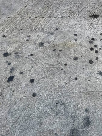 eine Fotografie einer Straße mit vielen Flecken auf dem Boden.