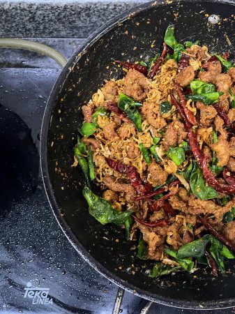a photography of a wok with a stir fry of food on a stove.