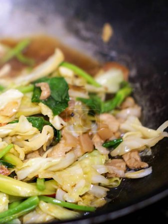 a photography of a wok filled with lots of food and vegetables.