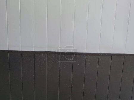 eine Fotografie einer Toilette mit schwarzem Sitz und weißer Wand.