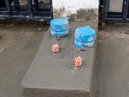 Photo for A photography of a concrete block with two blue buckets and a red can. - Royalty Free Image