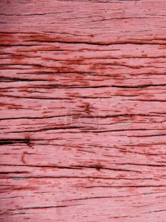 a photography of a red wood plank with a small bird perched on it.