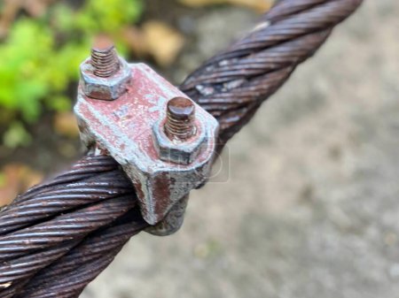 una fotografía de un primer plano de un alambre de metal con un par de tuercas.