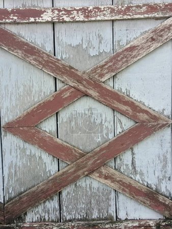 une photographie d'une porte en bois avec un motif de croix dessus.
