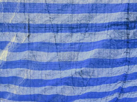eine Fotografie eines blau-weiß gestreiften Tuchs mit einem schwarzen Streifen.