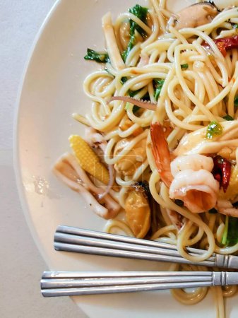 a photography of a plate of noodles with shrimp and vegetables.