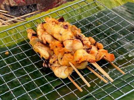 a photography of a grill with a bunch of skewers on it.
