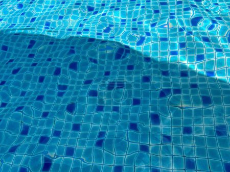 Photo for A photography of a pool with a blue tiled floor and a shadow of a person. - Royalty Free Image