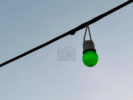 Foto de Una fotografía de una luz verde colgando de un alambre. - Imagen libre de derechos