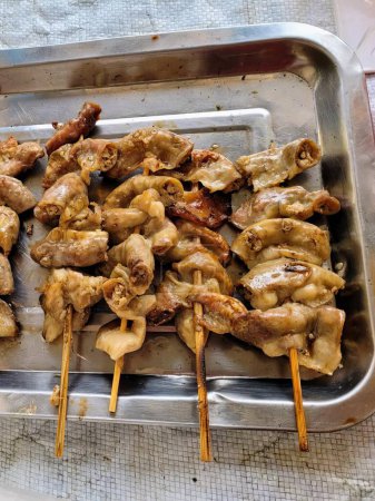 a photography of a tray of chicken skewers on a table.