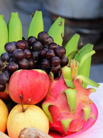 eine Fotografie einer Schüssel voller Früchte mit Bananen, Äpfeln und Orangen.