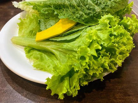 a photography of a plate of lettuce and a banana on a table.