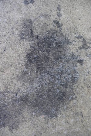 a photography of a dirty floor with a black spot on it.