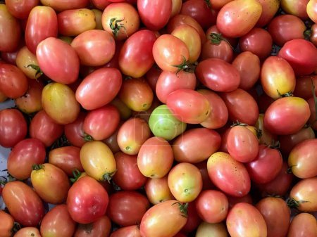 una fotografía de una pila de tomates con verdes y rojos.