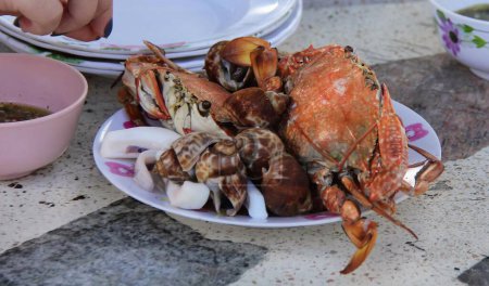 eine Fotografie eines Tellers mit Krabben und Venusmuscheln auf einem Tisch.