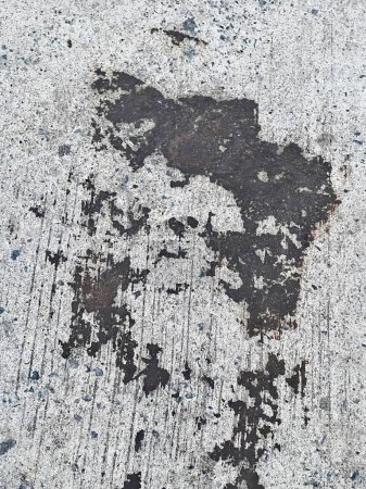 a photography of a dirty sidewalk with a black and white picture of a person.