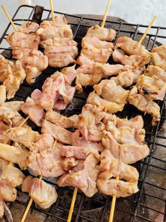 a photography of a grill with chicken skewers on it.