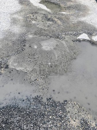 a photography of a pothole with a fire hydrant in the middle of it.