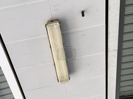 Foto de Una fotografía de una luz blanca colgando del techo de un edificio. - Imagen libre de derechos