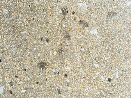 a photography of a close up of a concrete surface with small rocks.