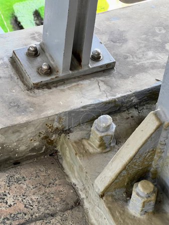 una fotografía de un poste de metal con un par de tuercas.