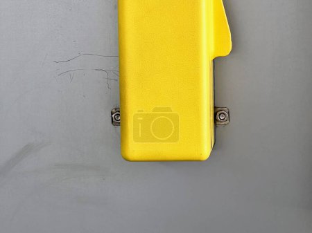 una fotografía de una maleta amarilla sentada sobre una superficie gris.