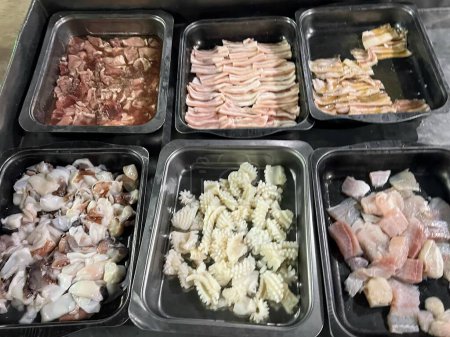 una fotografía de una variedad de alimentos en recipientes en un mostrador.