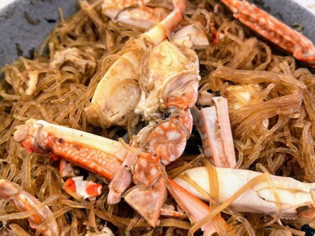 Foto de Una fotografía de un tazón de patas de cangrejo y fideos con un tenedor. - Imagen libre de derechos