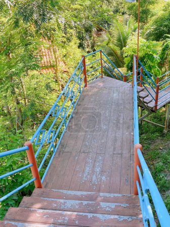Photo for A photography of a wooden walkway with blue railings leading to a wooden deck. - Royalty Free Image