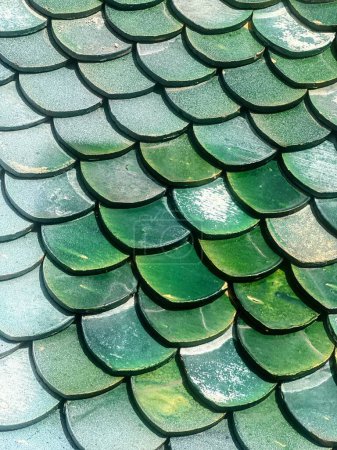 une photographie d'un motif d'échelle de dragon vert sur un toit.