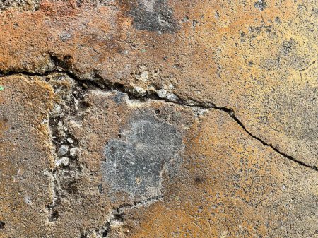 una fotografía de una grieta en una pared de roca con un pequeño agujero en ella.