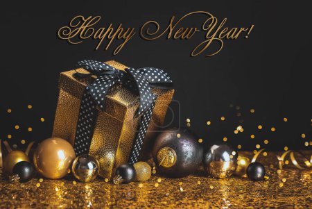 Photo for Merry Christmas Happy New Year! Gift in a golden box with a bow on a black and gold background - Royalty Free Image