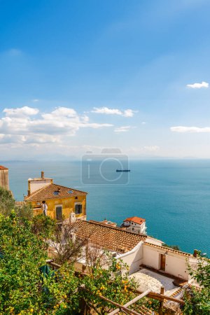 Italian landscape. Old houses with tiled roofs on a background of blue sea and sky