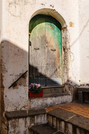 Foto de Una vieja puerta de madera en una casa vieja y una maceta de flores - Imagen libre de derechos